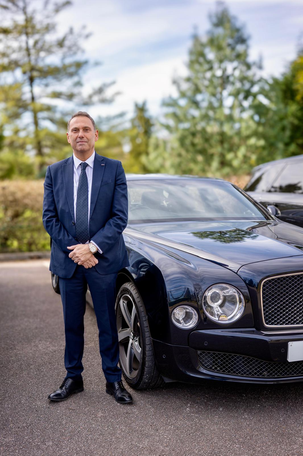 MCO Prestige chauffeur beside a Bentley